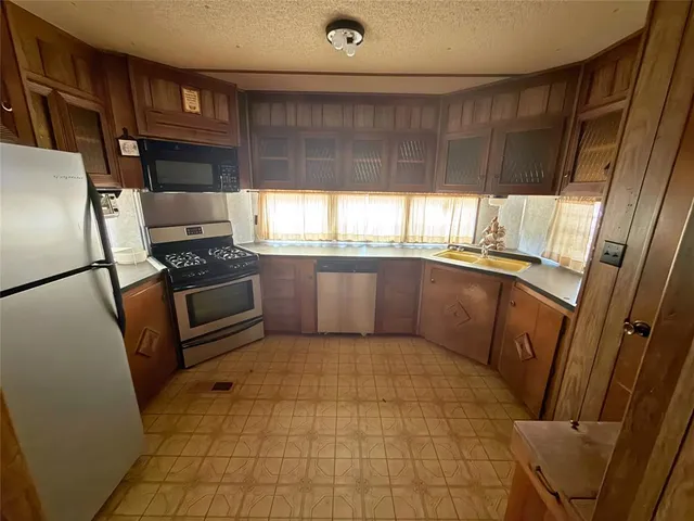 a kitchen with stainless steel appliances granite countertop a refrigerator and a sink