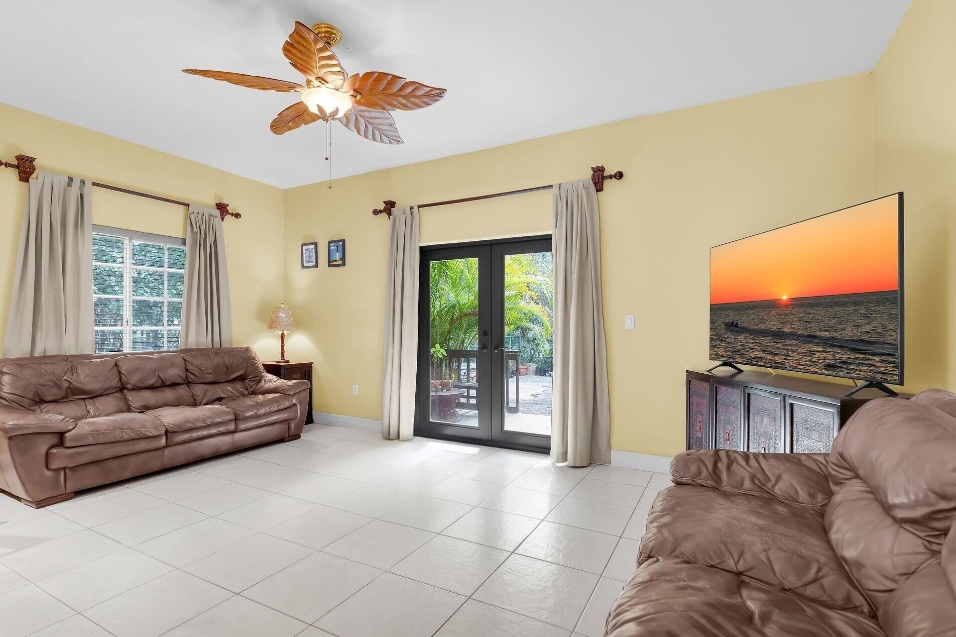 6 Fishermans Trail Key Largo, FL 33037 - Photo 11 of 50 a living room with furniture a flat screen tv and a large window