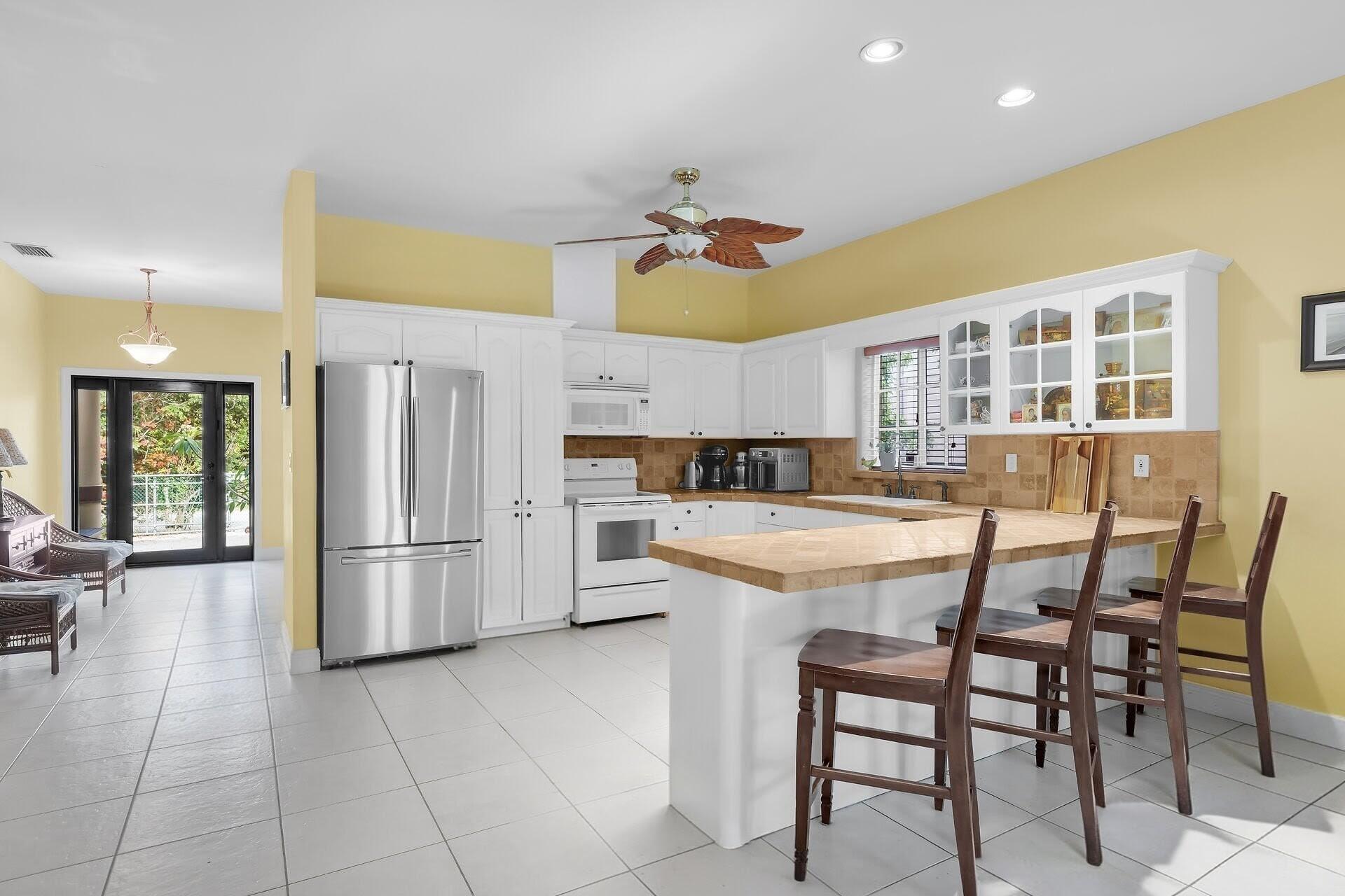 6 Fishermans Trail Key Largo, FL 33037 - Photo 7 of 50 a kitchen with a refrigerator a table and chairs in it