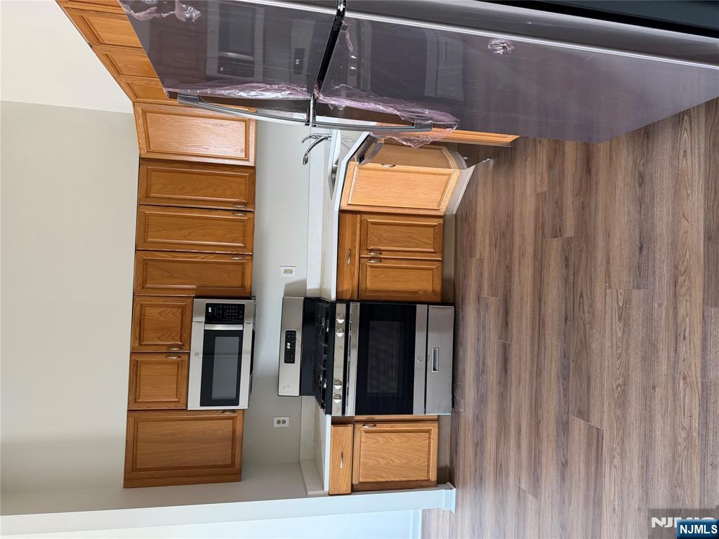 250 Park Avenue, Unit 1 East Rutherford, NJ 07073 - Photo 4 of 8 a kitchen with stainless steel appliances granite countertop a stove a microwave and a refrigerator