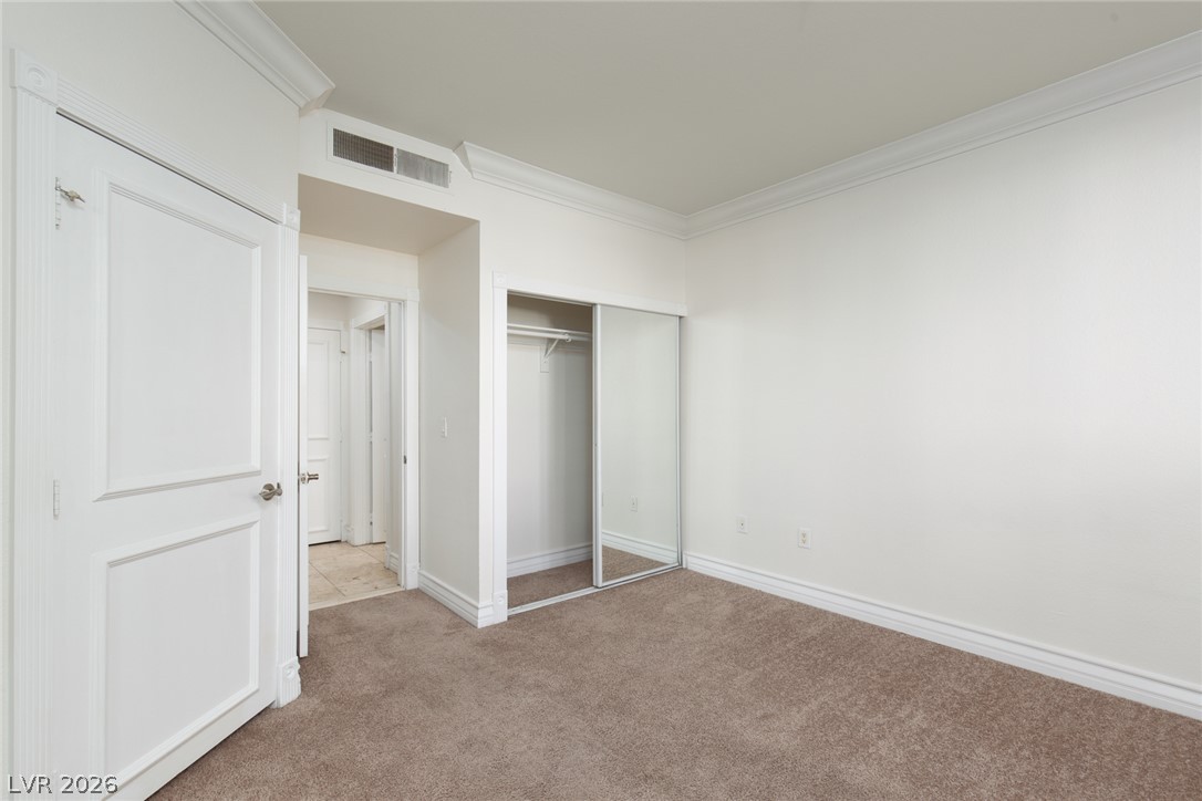 210 East Flamingo Road, Unit 117 Las Vegas, NV 89169 - Photo 18 of 24 Classic crown molding and soft carpeting define this versatile space.