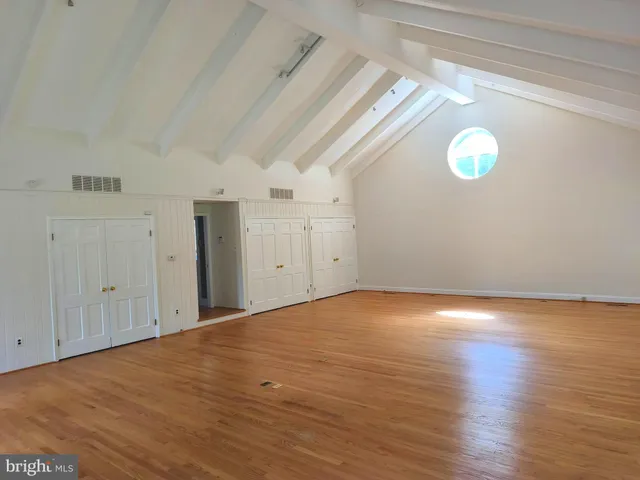 a view of empty room with wooden floor and fireplace