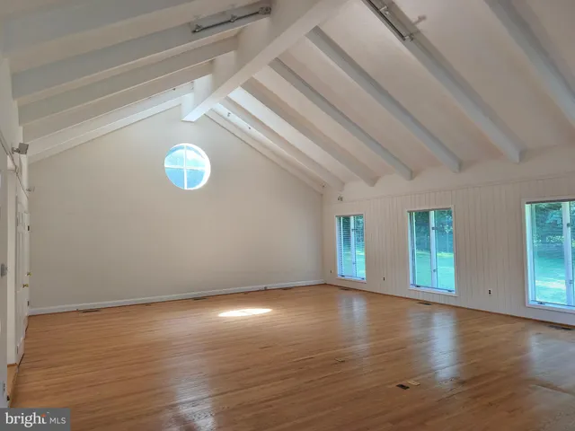 a view of empty room with wooden floor and fireplace