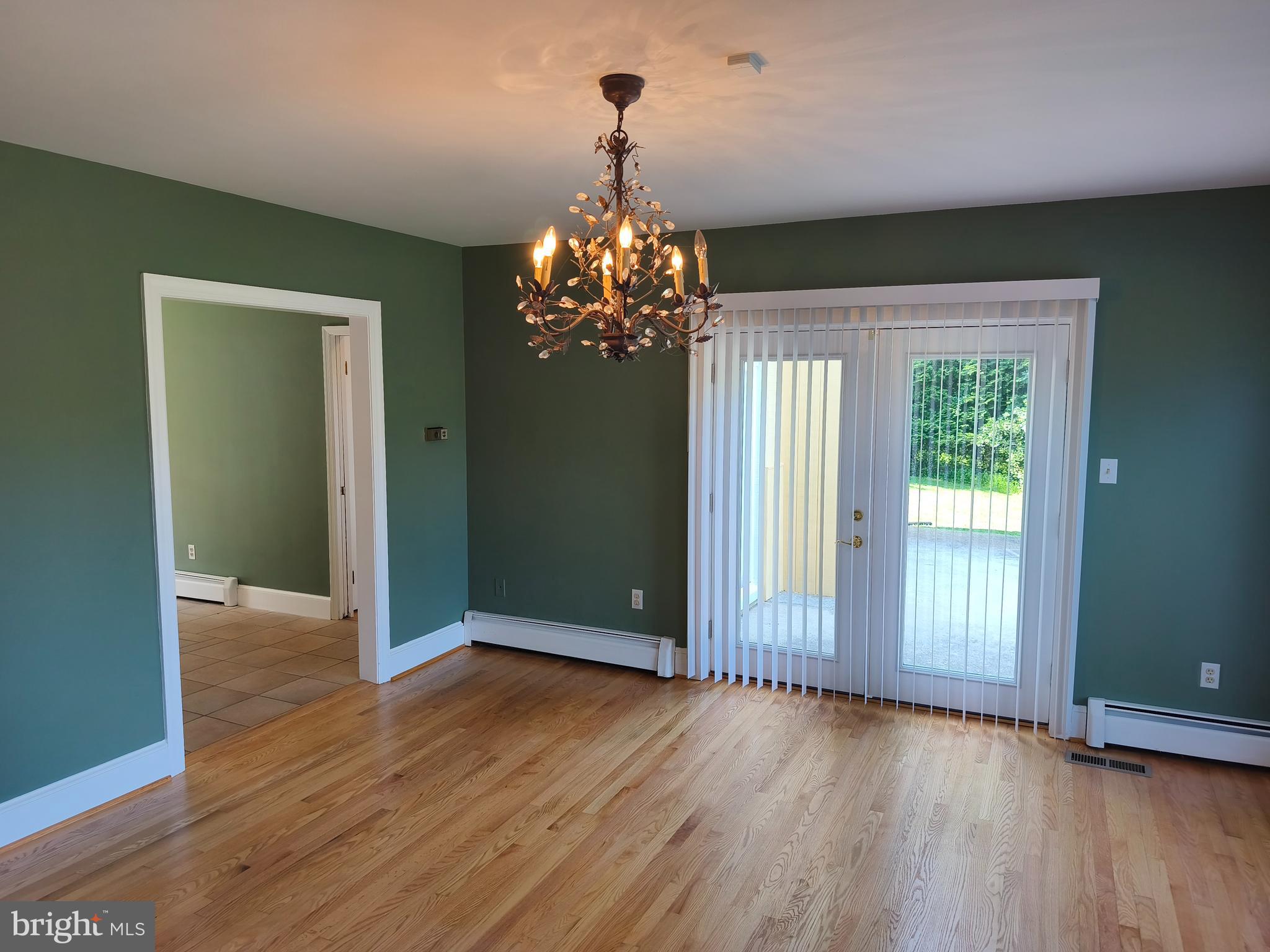 901 Walker Road Great Falls, VA 22066 - Photo 16 of 57 an empty room with wooden floor chandelier and windows