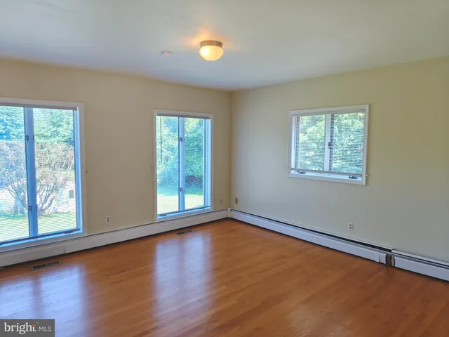 an empty room with fireplace and windows