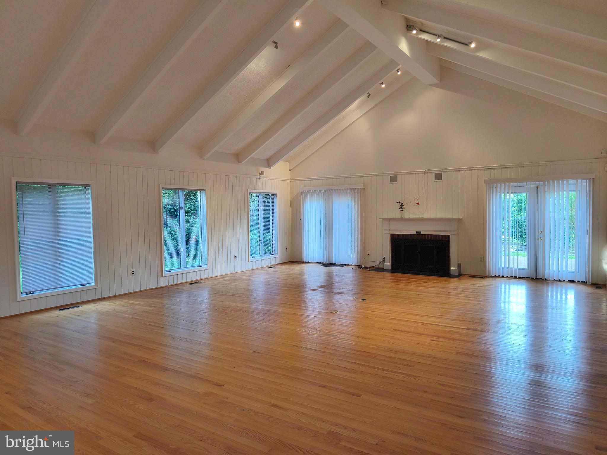 901 Walker Road Great Falls, VA 22066 - Photo 9 of 57 an empty room with wooden floor fireplace and windows