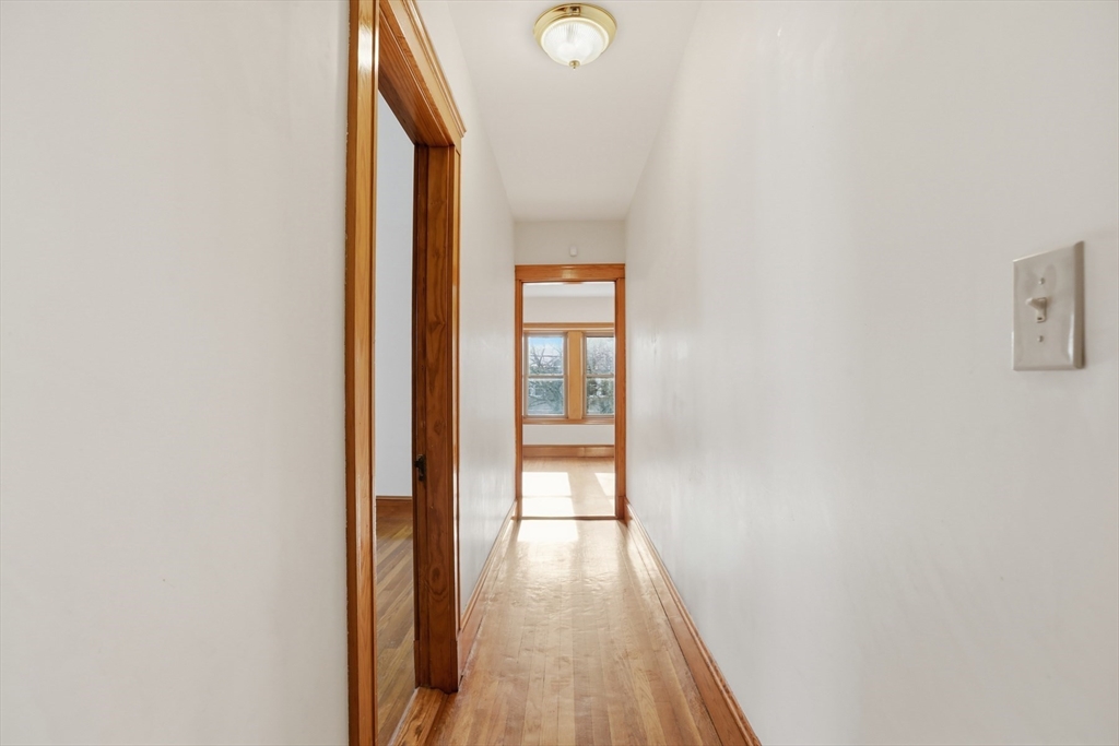 67 Lake Street, Unit 2 Arlington, MA 02474 - Photo 12 of 16 a view of a hallway with wooden floor and a window