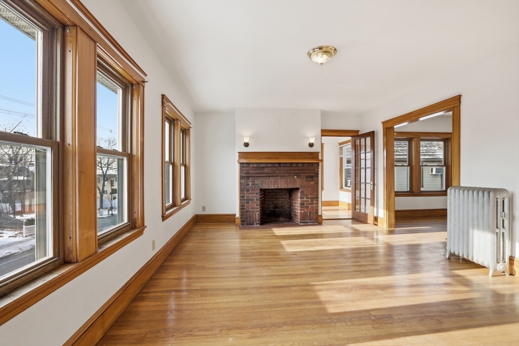 67 Lake Street, Unit 2 Arlington, MA 02474 - Photo 5 of 16 a view of an empty room with wooden floor and a window