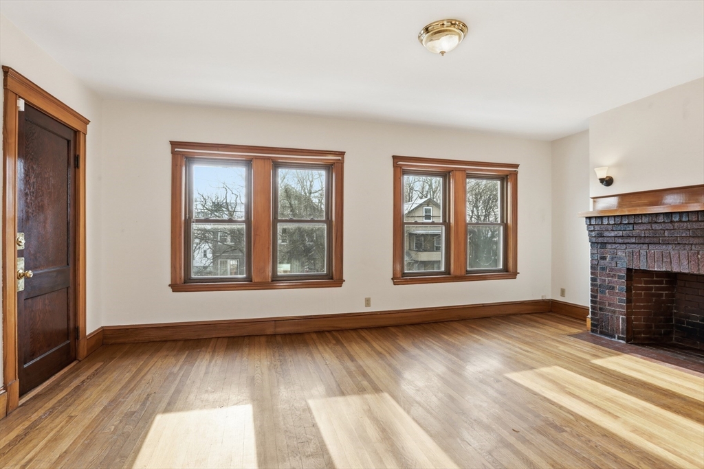 67 Lake Street, Unit 2 Arlington, MA 02474 - Photo 6 of 16 wooden floor fireplace and windows in an empty room