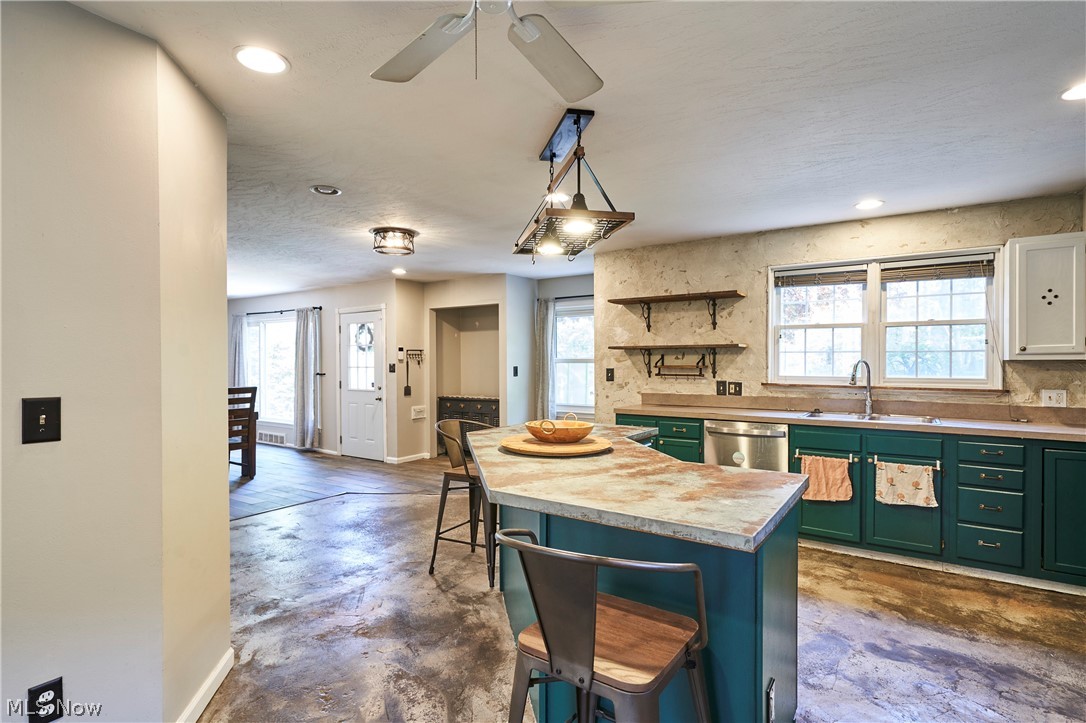 780 Bates Road Rocky River, OH 44116 - Photo 3 of 35 Kitchen featuring a central island with seating, a drop-in sink with a gooseneck faucet, teal-painted cabinetry, a built-in dishwasher, and exposed shelving