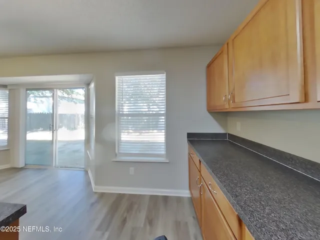 a kitchen with granite countertop a sink a stove and cabinets