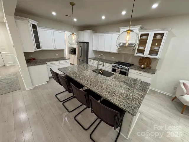 a kitchen with stainless steel appliances granite countertop a sink stove and refrigerator