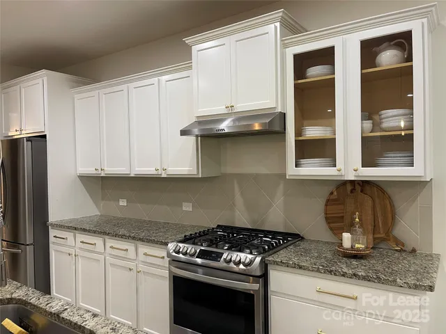 a kitchen with granite countertop a sink stainless steel appliances and cabinets