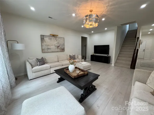 a living room with furniture and a chandelier