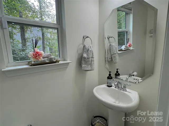 a bathroom with a sink mirror and window
