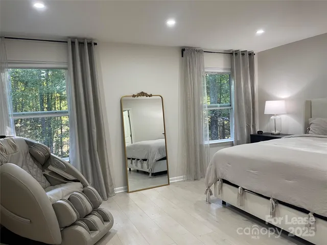 a bedroom with a bed and a large window