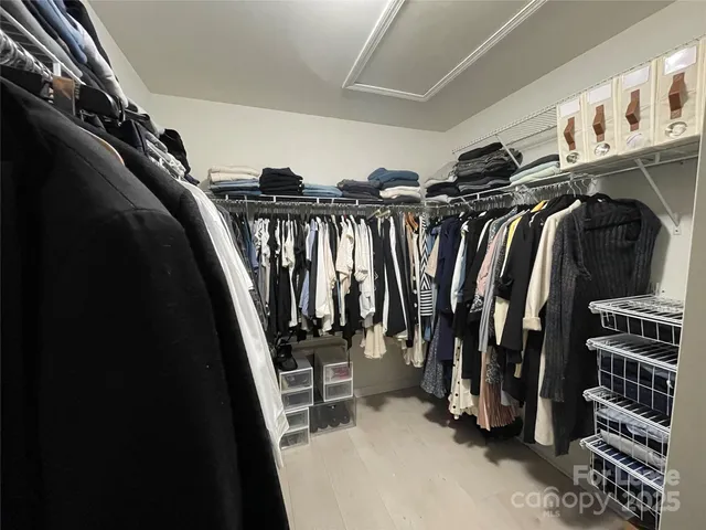 a view of walk in closet with clothes and shoes