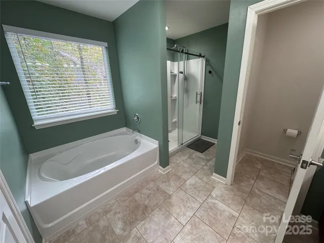 a spacious bathroom with a bathtub and shower