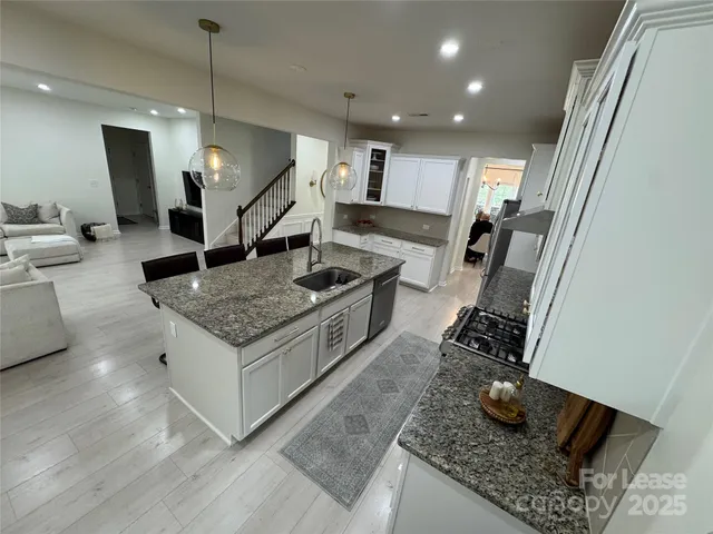 a kitchen with stainless steel appliances granite countertop sink stove and cabinets