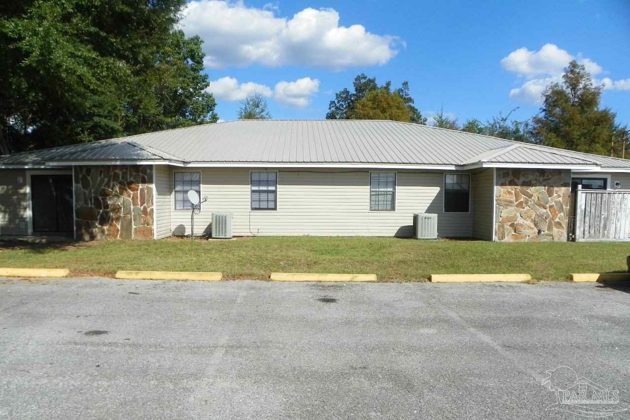 a view of yellow house with outdoor space and a yard