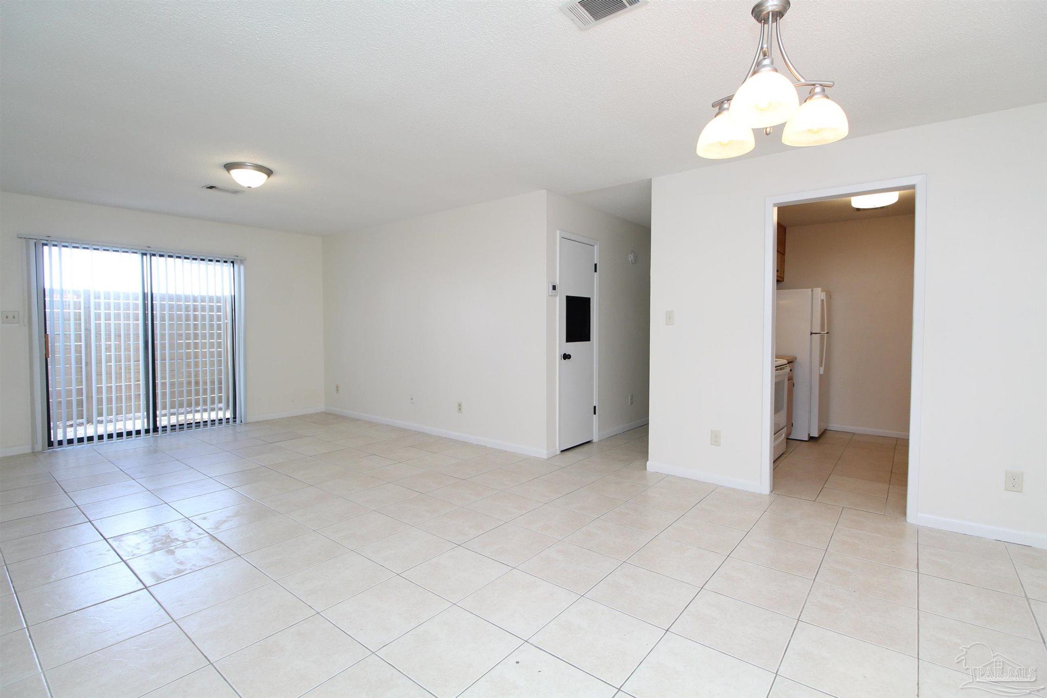 4964 West Spencer Field Road, Unit 6 Pace, FL 32571 - Photo 5 of 15 a view of an empty room with a chandelier