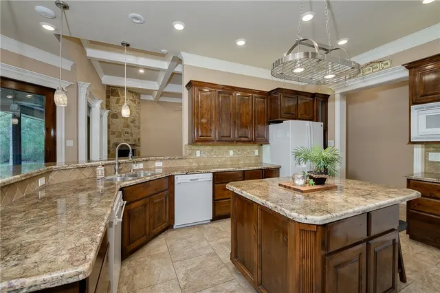 a bathroom with a granite countertop sink a toilet and shower