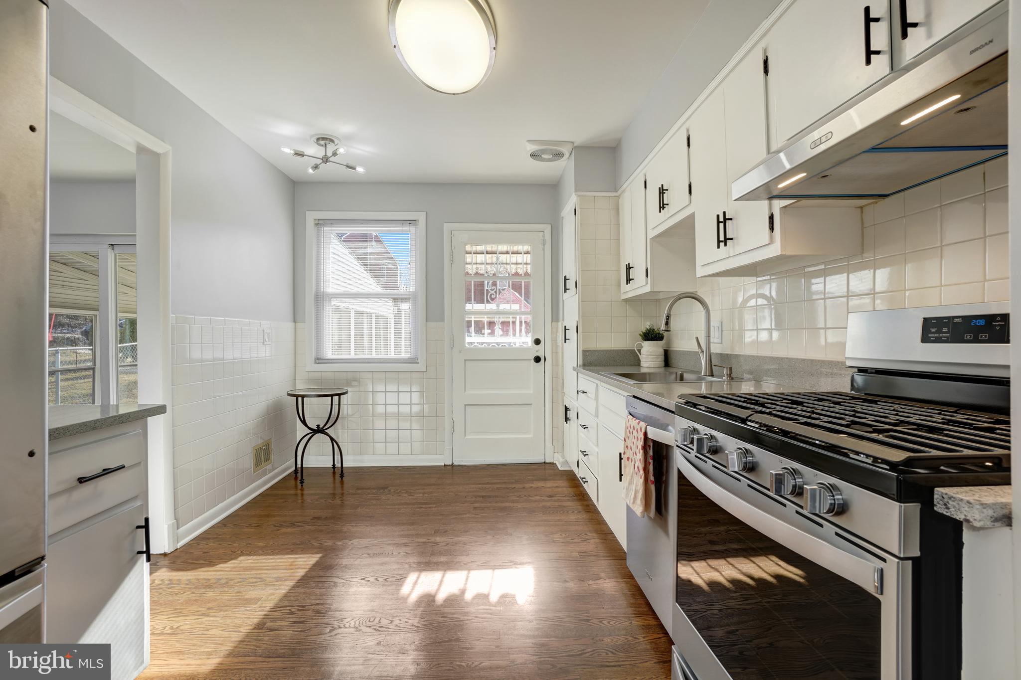 1446 Roxanna Road Northwest Washington, DC 20012 - Photo 12 of 34 a kitchen with stainless steel appliances granite countertop a stove and a sink