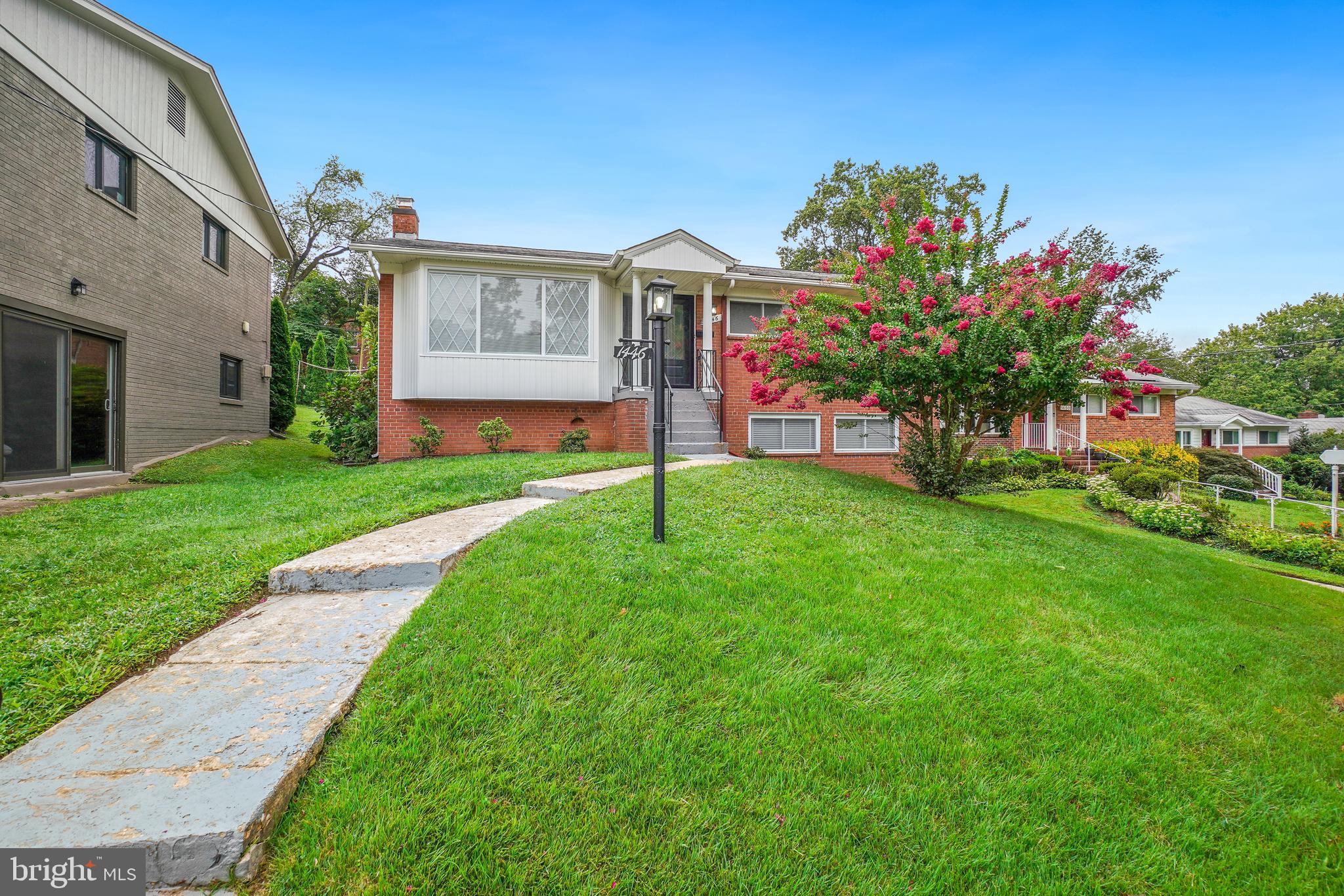 1446 Roxanna Road Northwest Washington, DC 20012 - Photo 2 of 34 a front view of a house with a big yard and a large tree