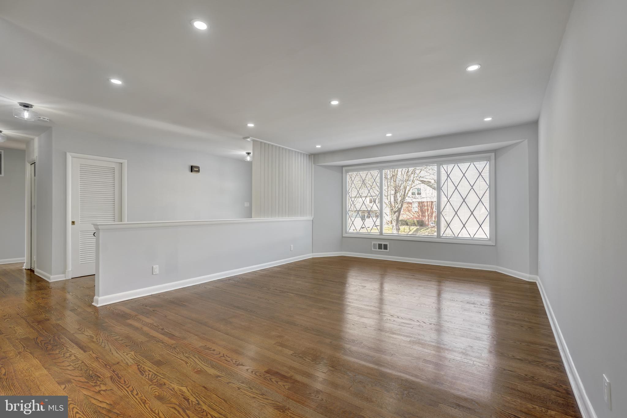 1446 Roxanna Road Northwest Washington, DC 20012 - Photo 7 of 34 a view of an empty room with wooden floor and a window