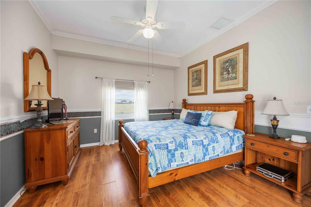 48 Bunker Road Rotonda West, FL 33947 - Photo 27 of 59 a bedroom with a bed and a dresser with wooden floor