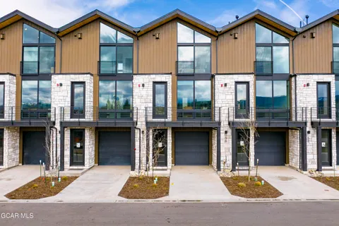 a kitchen with stainless steel appliances granite countertop a stove a refrigerator and a dining table with wooden floor
