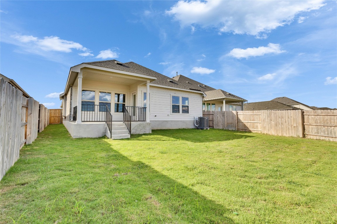 13709 Tucker Hedge Pass Elgin, TX 78621 - Photo 13 of 14 Rear view of house featuring a fenced backyard, roof with shingles, and a patio