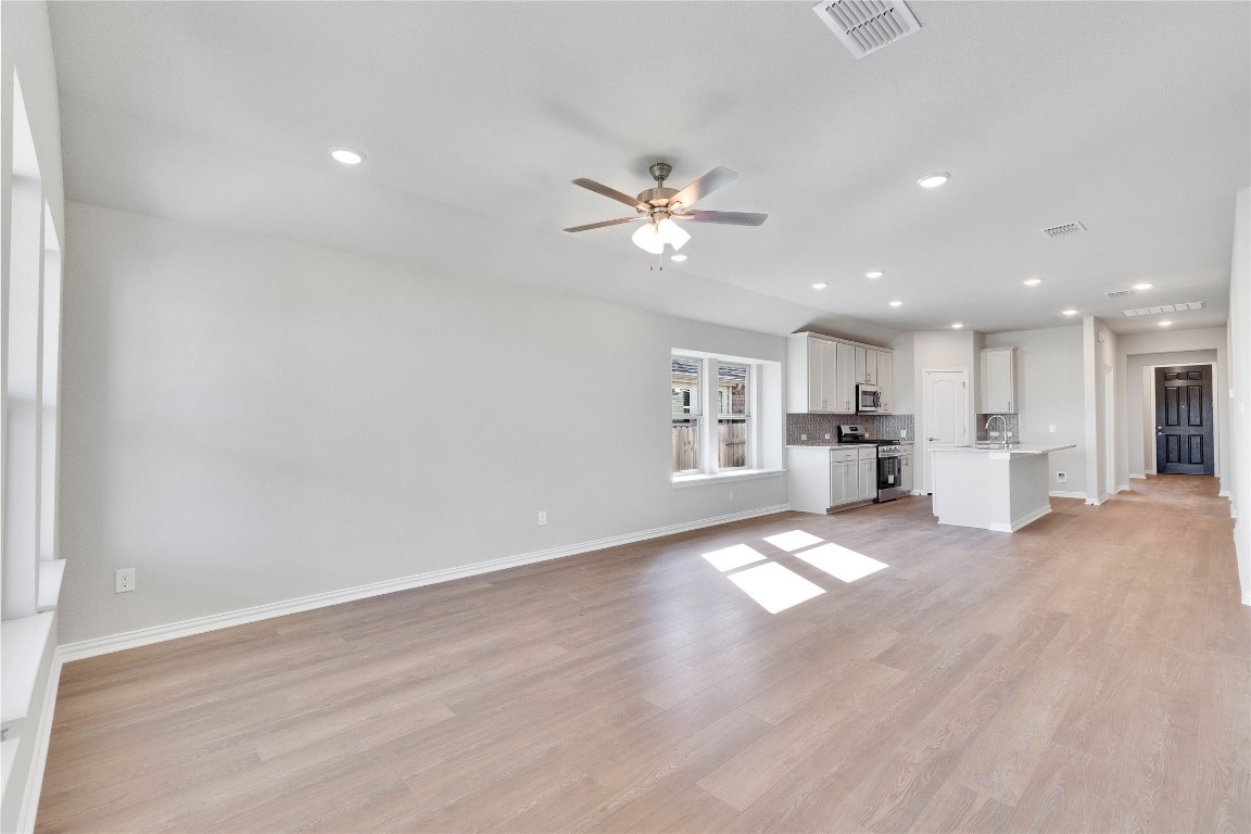 13709 Tucker Hedge Pass Elgin, TX 78621 - Photo 4 of 14 Unfurnished living room featuring light wood-style flooring, recessed lighting, and a ceiling fan