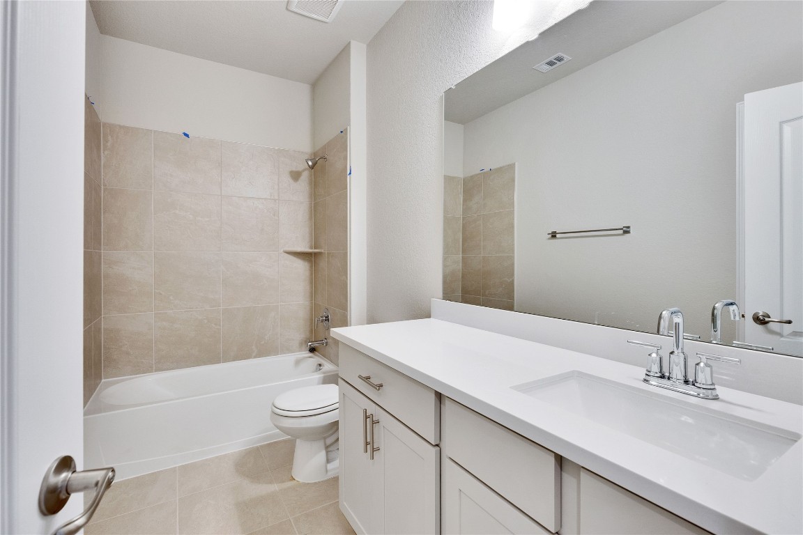 13709 Tucker Hedge Pass Elgin, TX 78621 - Photo 10 of 14 Bathroom featuring shower combination, vanity, and light tile patterned flooring