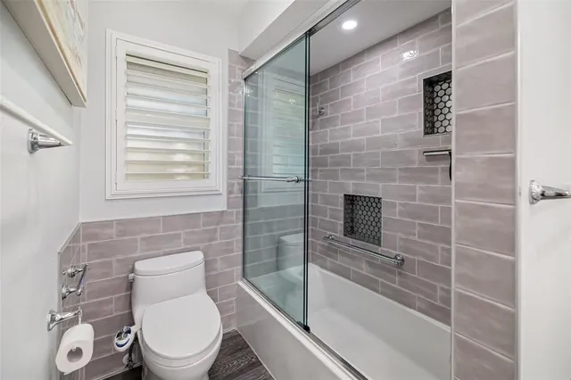 a bathroom with a granite countertop sink a mirror and shower