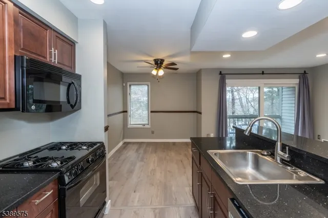a kitchen with granite countertop a sink stove and refrigerator