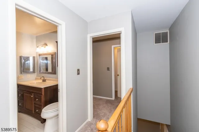 a view of bathroom with a toilet sink and mirror