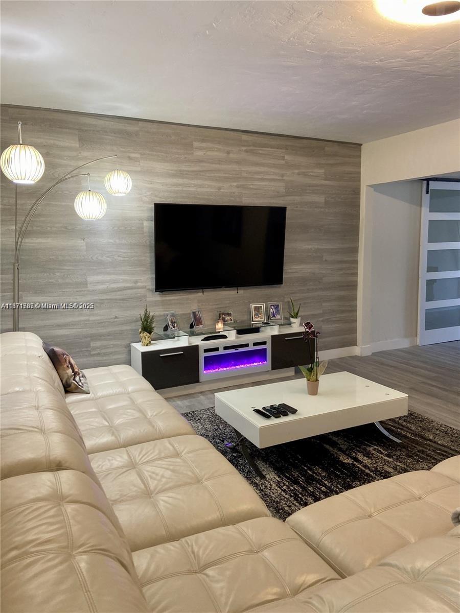 6765 Southwest 17th Street, Unit 6765 Miami, FL 33155 - Photo 6 of 9 a living room with furniture and a flat screen tv