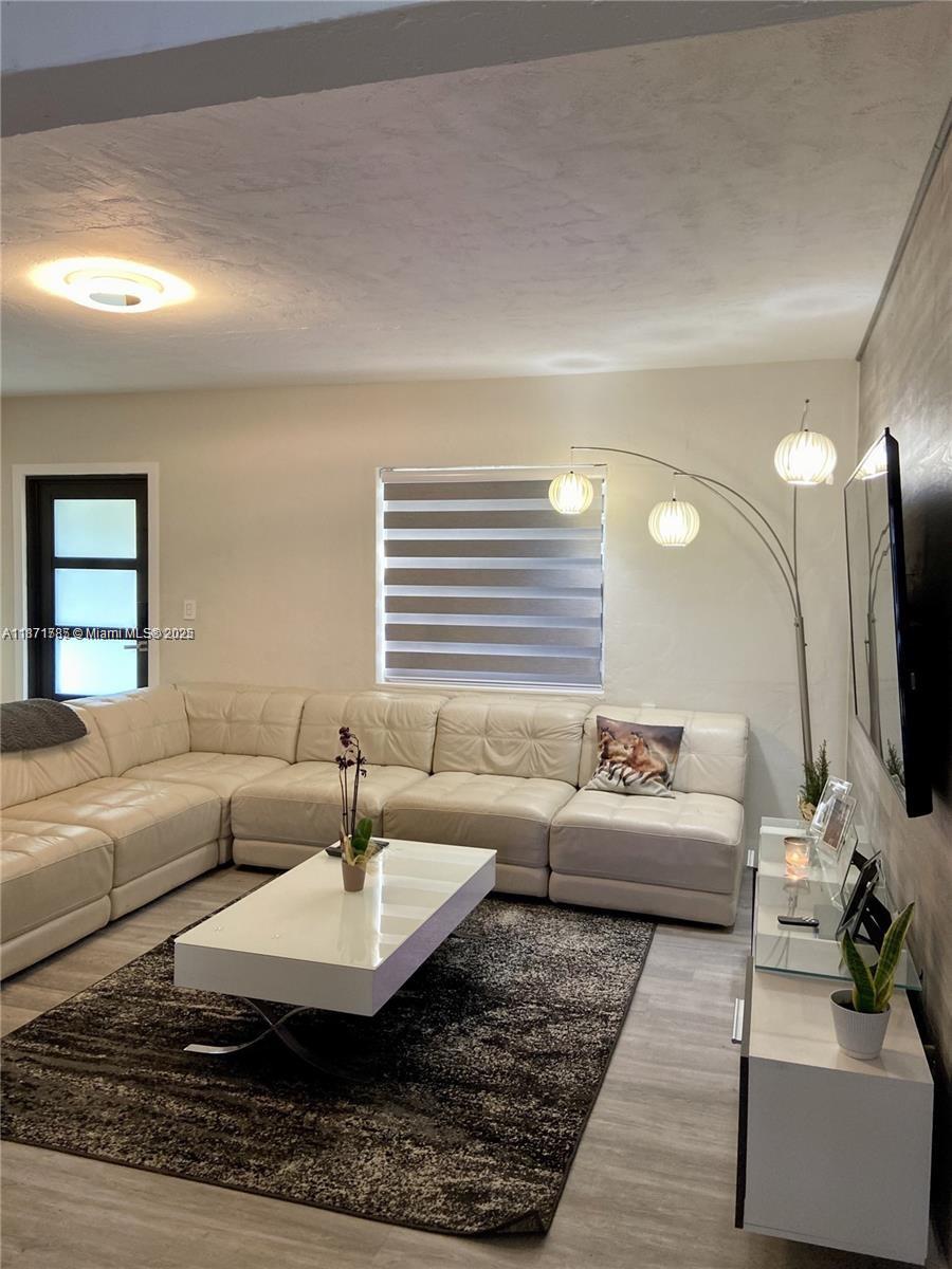 6765 Southwest 17th Street, Unit 6765 Miami, FL 33155 - Photo 7 of 9 a living room with furniture and a flat screen tv