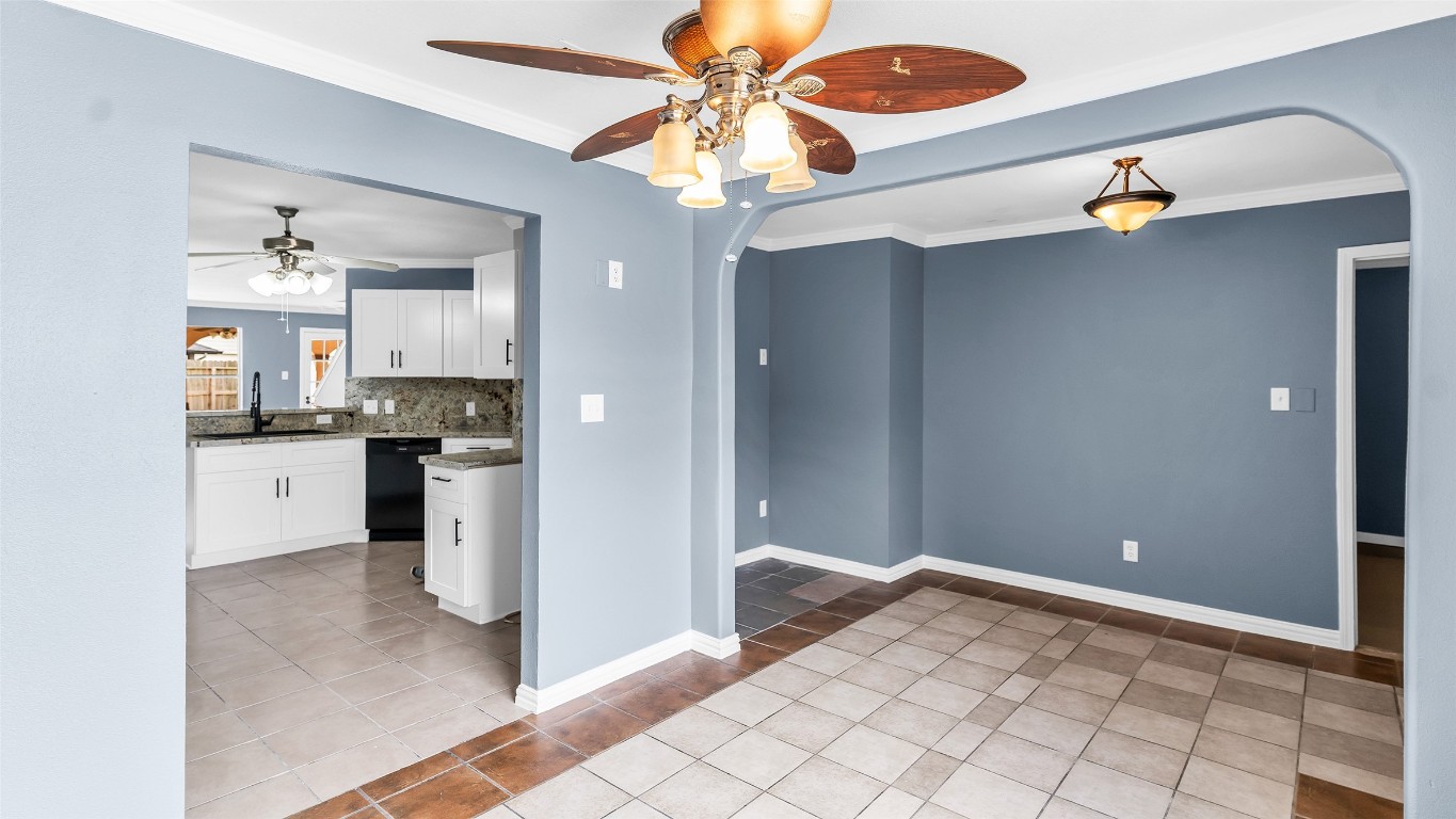 5534 Calm Court Houston, TX 77084 - Photo 11 of 48 The kitchen seamlessly opens into the breakfast room, creating a functional and inviting space for daily living. Additionally, the room features a distinctive ceiling fan with leaf-shaped blades and a light fixture, combining both style and practicality.