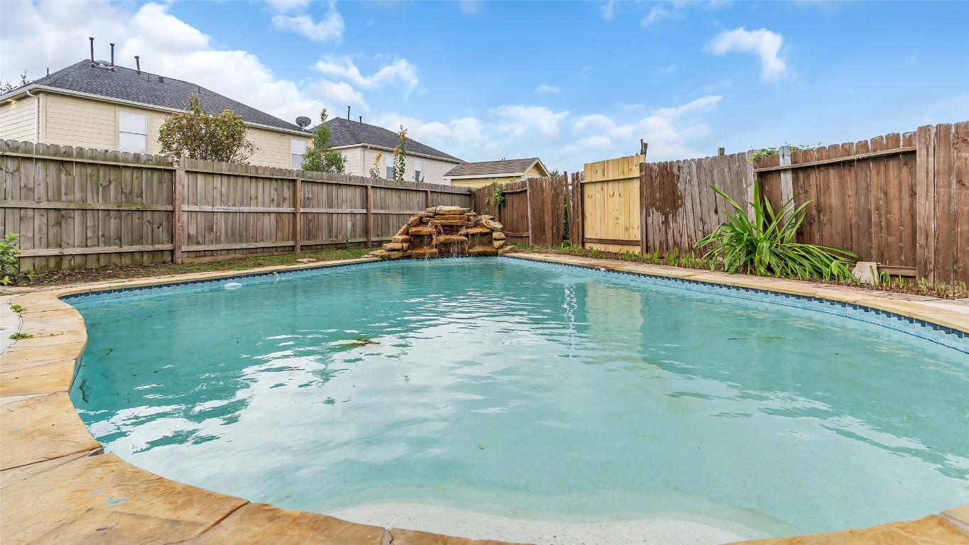 5534 Calm Court Houston, TX 77084 - Photo 38 of 48 Transform your spacious backyard into the ultimate oasis, featuring a stunning Gunite swimming pool with a captivating rock waterfall. This inviting space offers relaxation and enjoyment for you and your guests.