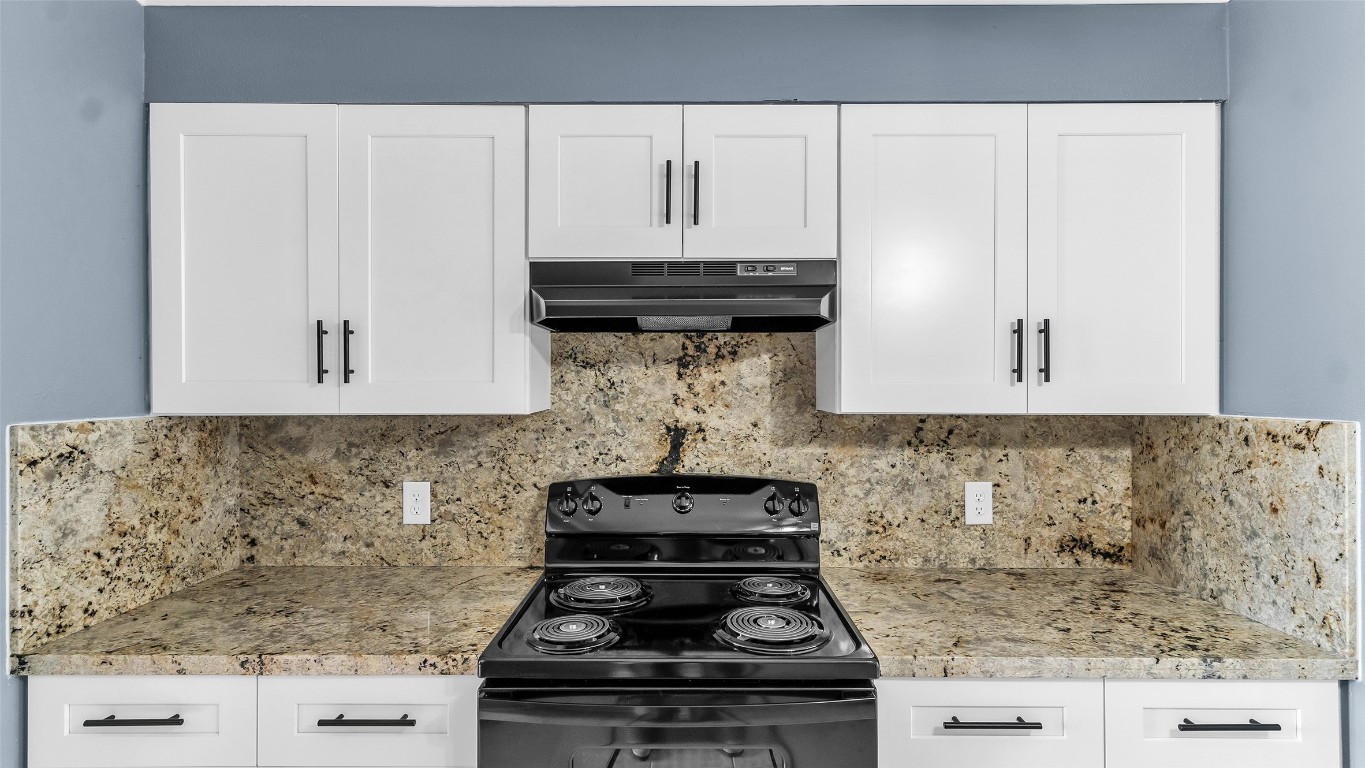 5534 Calm Court Houston, TX 77084 - Photo 9 of 48 a kitchen with a stove and a white cabinet