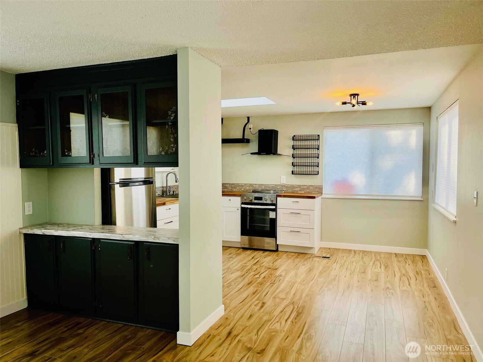 545 Hendricks Street, Unit 13 Port Townsend, WA 98368 - Photo 6 of 22 a view of a kitchen with stainless steel appliances wooden floor and living room