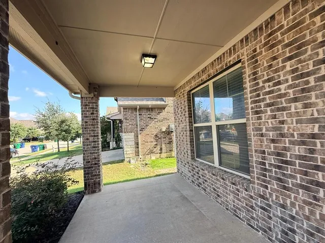 a view of a porch with a floor to ceiling window next to a yard