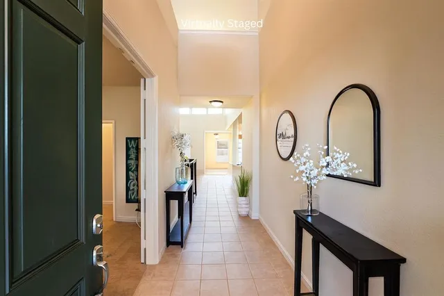 a hall way with furniture a mirror and a window