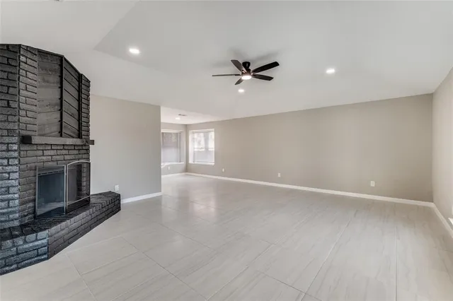 a view of an empty room with a fireplace and a window