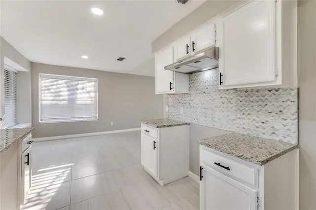 a kitchen with granite countertop a sink stainless steel appliances and cabinets