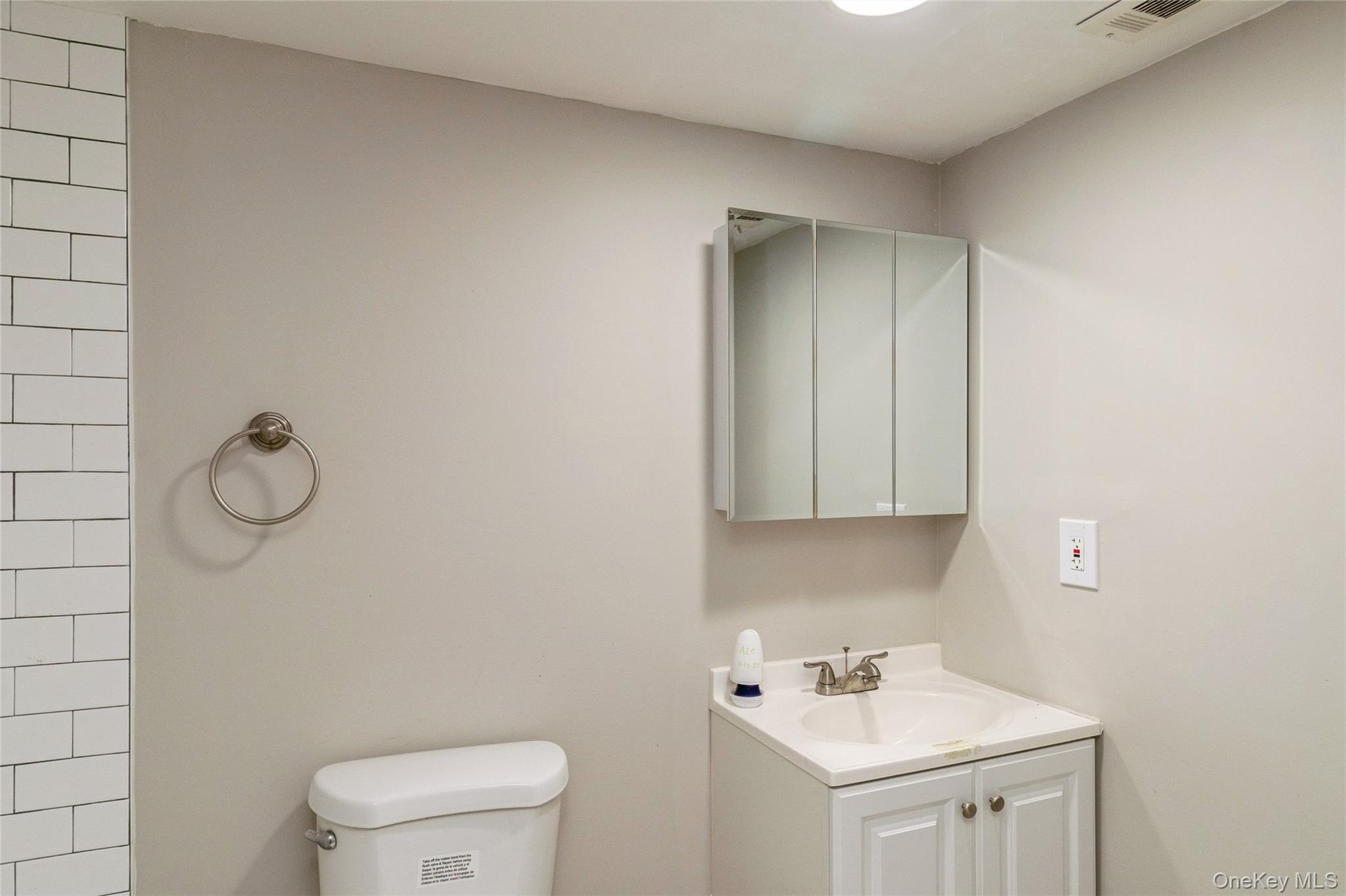 655 Middle Country Road, Unit 4D1 Coram, NY 11727 - Photo 23 of 27 a bathroom with a toilet sink vanity and mirror