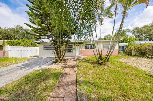 a view of a yard with plants and trees