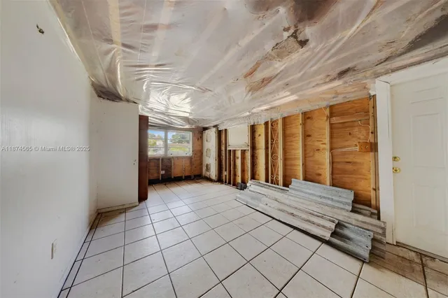 an empty room with windows and ceiling fan